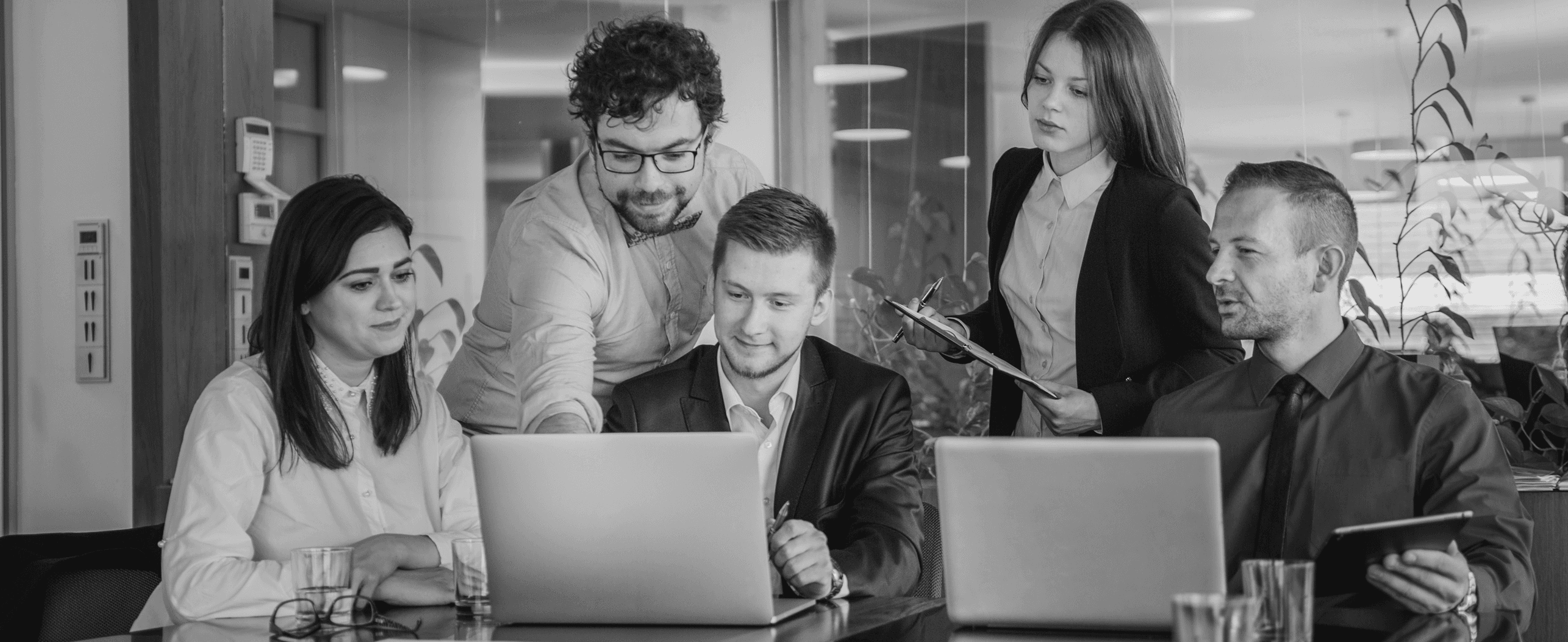 Professionals collaborating around laptops in an office